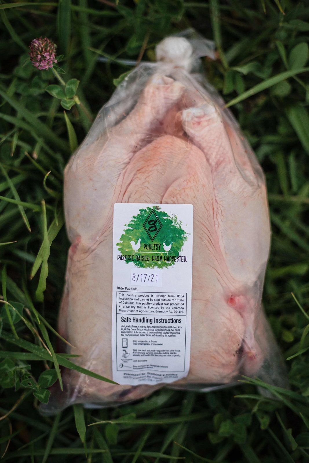 A whole packaged bird on the grass, the Diamond G label dated 8/17/21