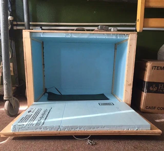 The home-built insulated box, plywood lined with blue foam board, standing open on the floor